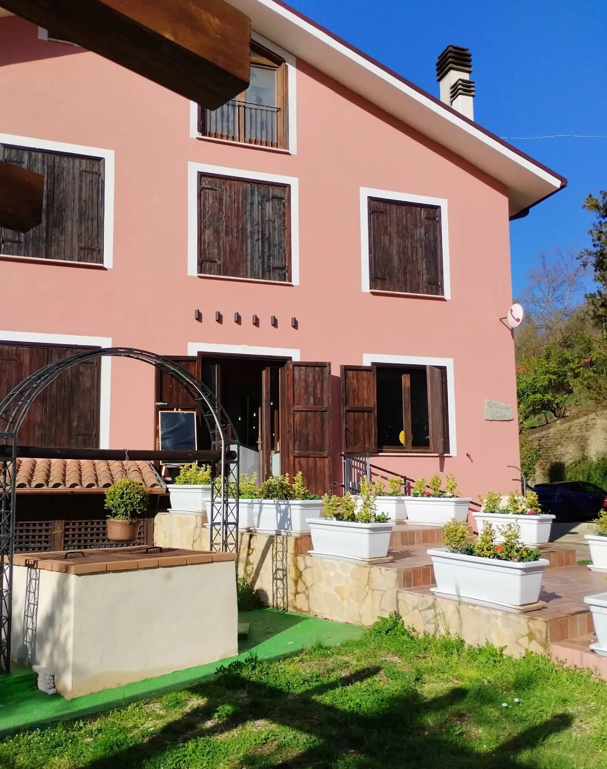 La villa vista dal prato, con la terrazza in mattoni